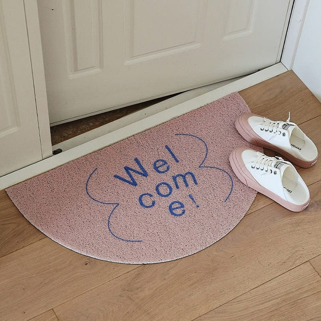 Halvrund dørmåtte med 'Welcome' tekst