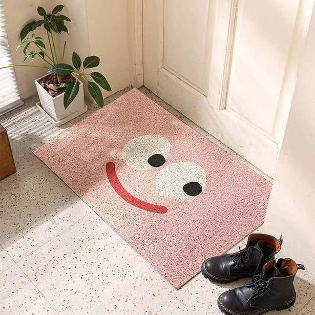 Lyserød dørmåtte med stort smiley design